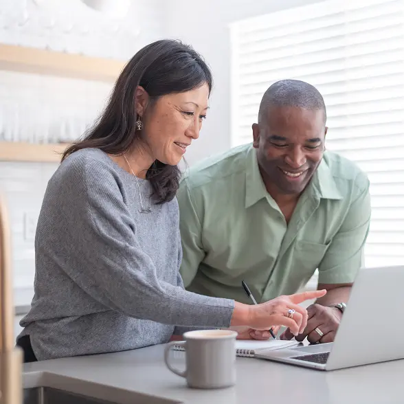 Inset_LegacyPlanning_Trust-converted couple pointing at a laptop screen and smiling for some reason
