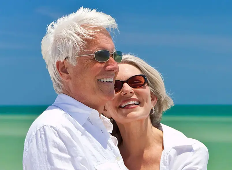 OurServices_M-converted Older couple on a beach embracing and smiling for some reason